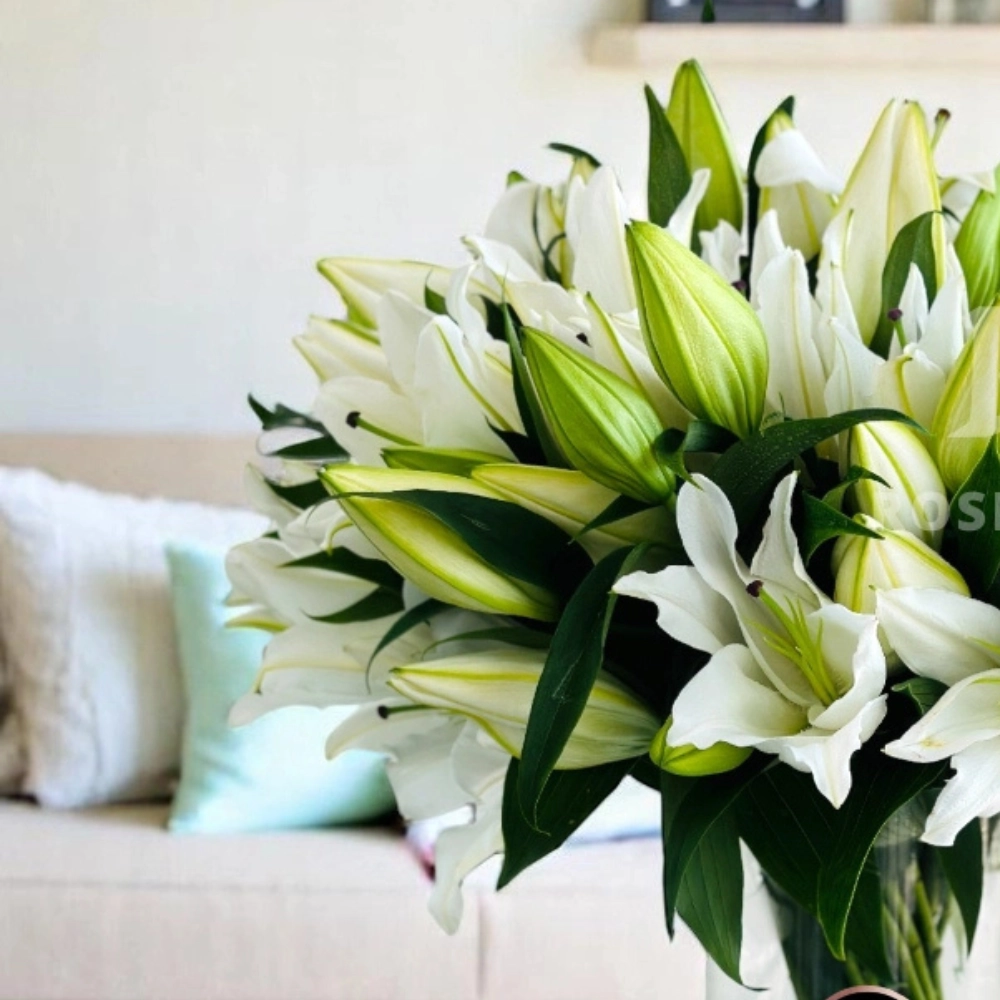 Arrangement of 10 white lilies in a glass vase