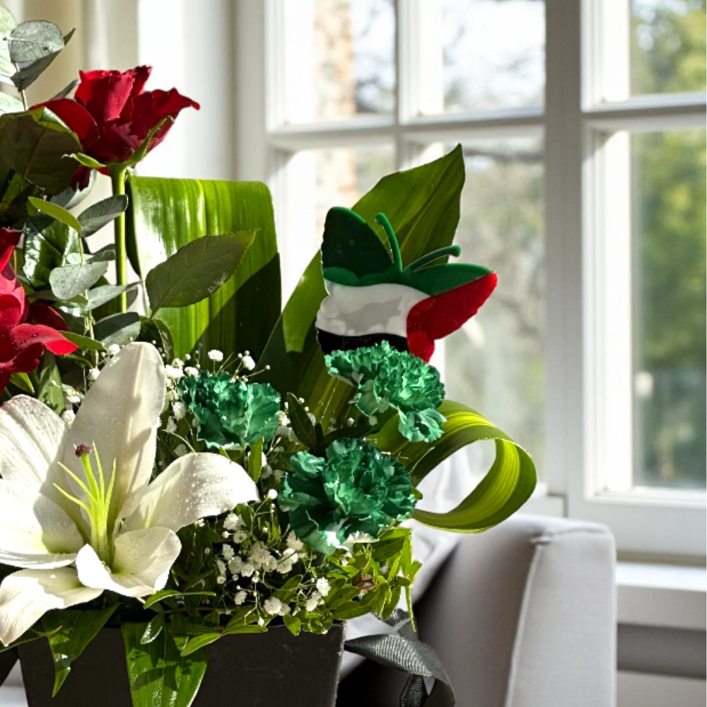 Arrangement of UAE color lilies and roses in a box