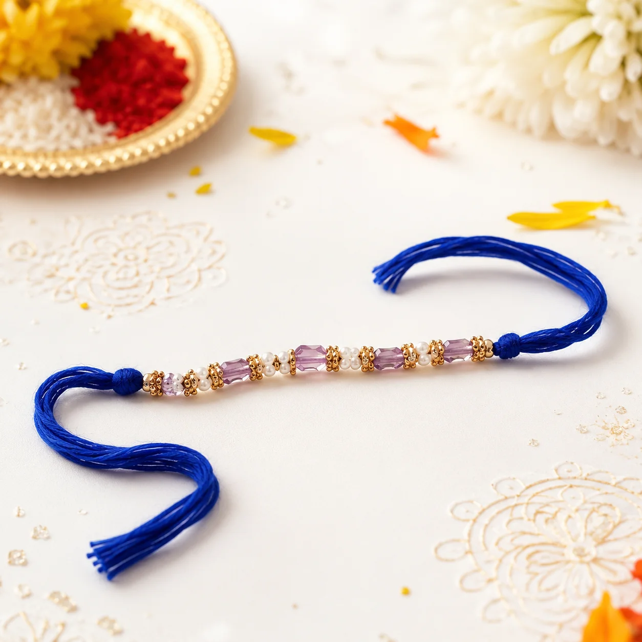 A luxurious purple crystal and pearl beaded rakhi with vibrant royal blue threads, set against a festive background.
